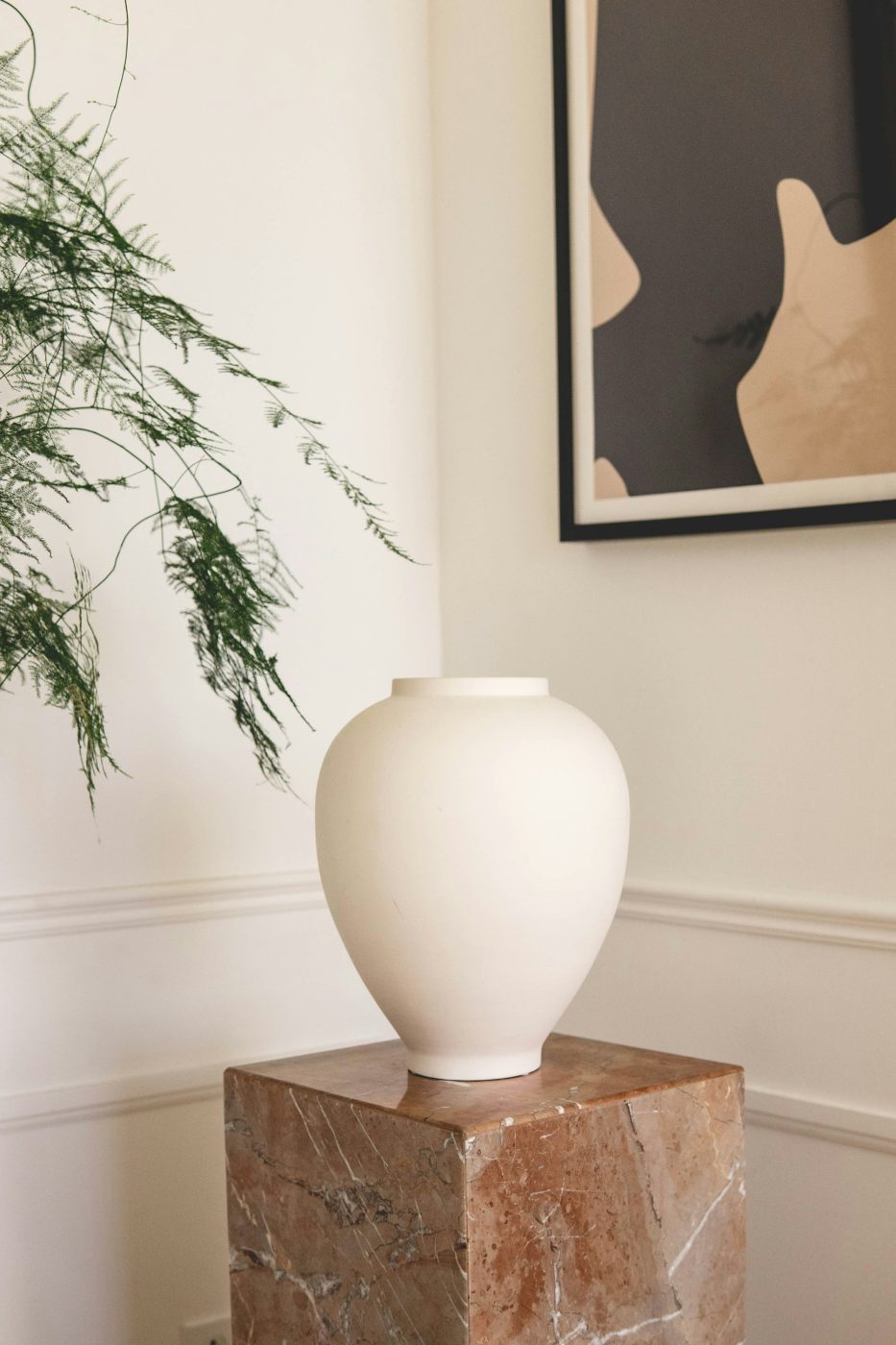 Vase en grès blanc posé sur un socle de marbre rose